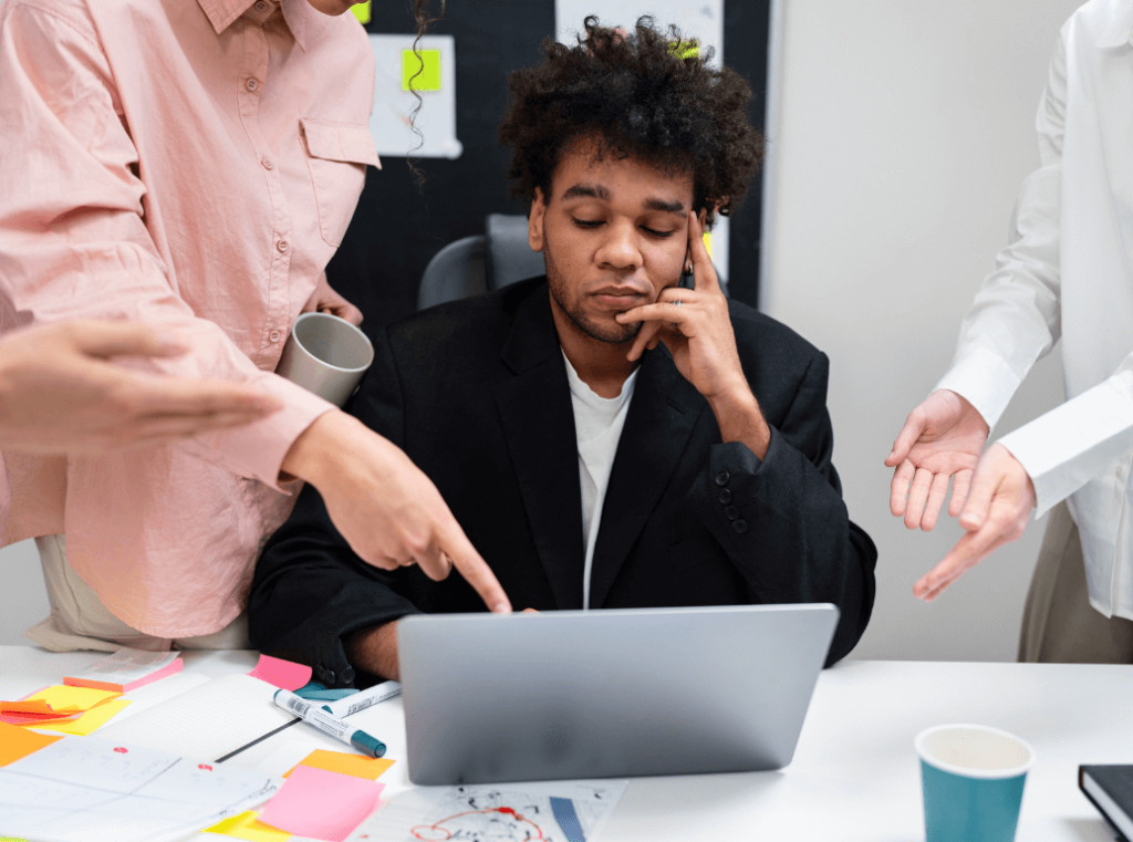 Frustrated employee underperforming at work while colleagues point out mistakes