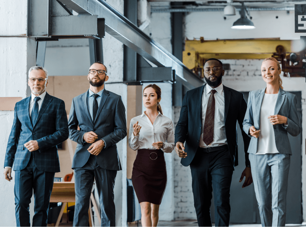 A diverse group of corporate executives walking through a modern office.